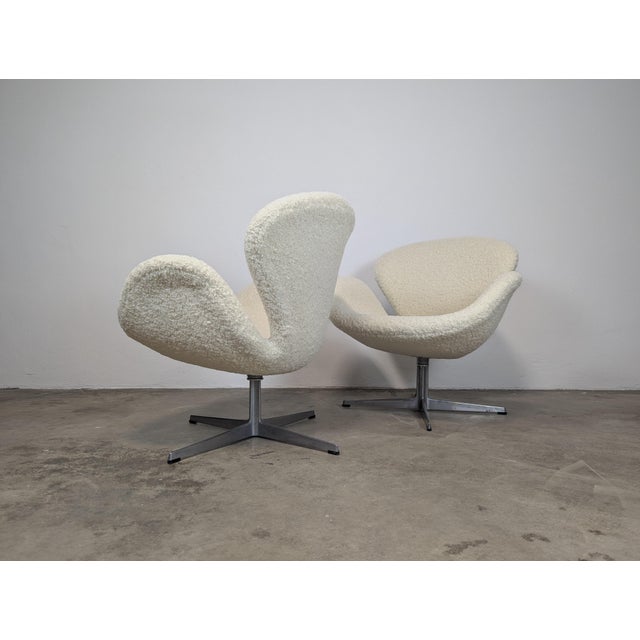 For sale is an exquisite pair of Mid Century Modern Swivel Swan Armchairs, masterfully designed by the renowned Arne...