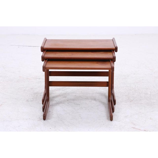 Vintage teak nesting tables in a clean Danish design. The striking, curved side panels and the neatly finished tabletops...