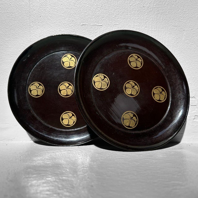 A rare set of nine black-lacquered antique wooden plates from the Meiji period (1868–1912). Dimensions: height: 2 cm,...