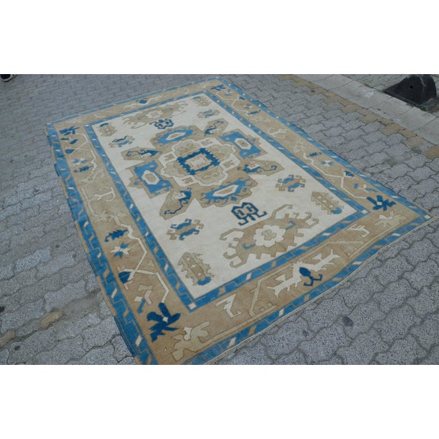 This is a vintage Turkish Oushak rug from the 1960s. The piece was hand-knotted.