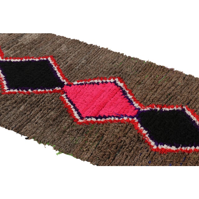 Hand-knotted in wool and originating from Morocco circa 1950-1960, this 3x7 vintage Moroccan rug is an extremely rare...