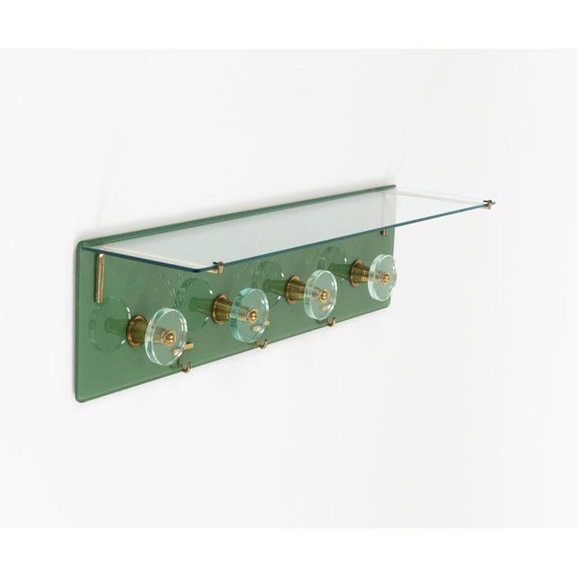 Midcentury amazing wall-mounted coat rack four circular hooks in glass and brass with top glass shelf by Cristal Art. Made...