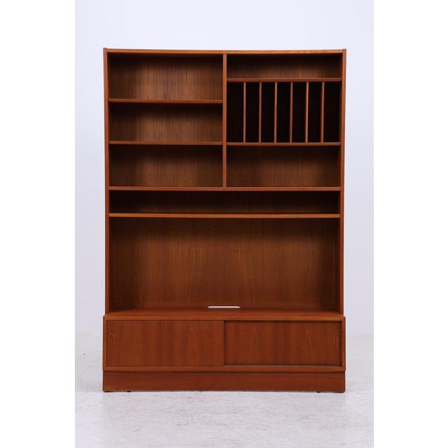 A large teak shelving unit by Poul Hundevad with a clean design and practical layout. The piece offers open shelving,...