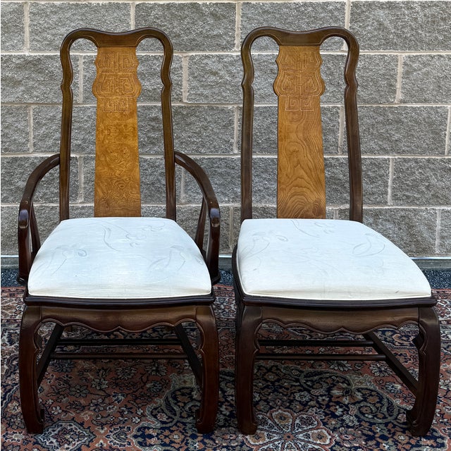 A pair of Universal Furniture Asian Mings style dining chairs including one armchair and one side chair. They feature dark...