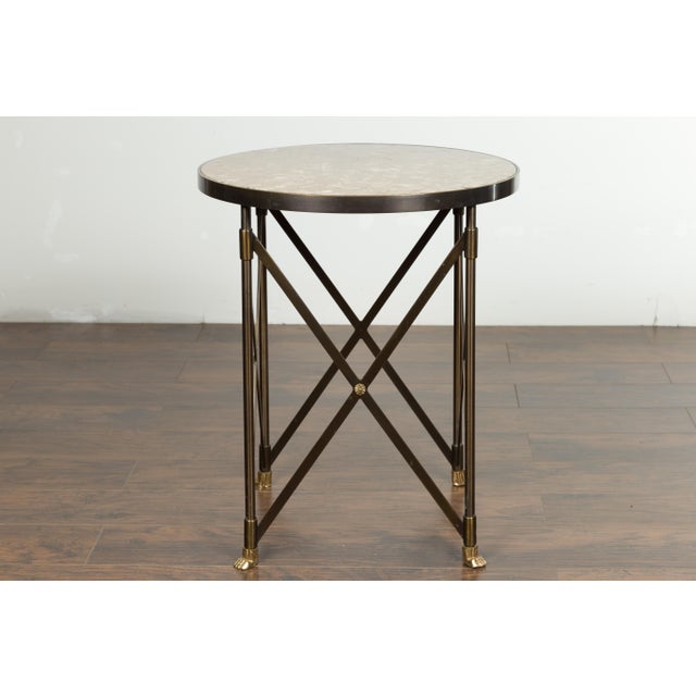 An Italian vintage bronze side table from the mid 20th century, with variegated marble top and paw feet. Created in Italy...