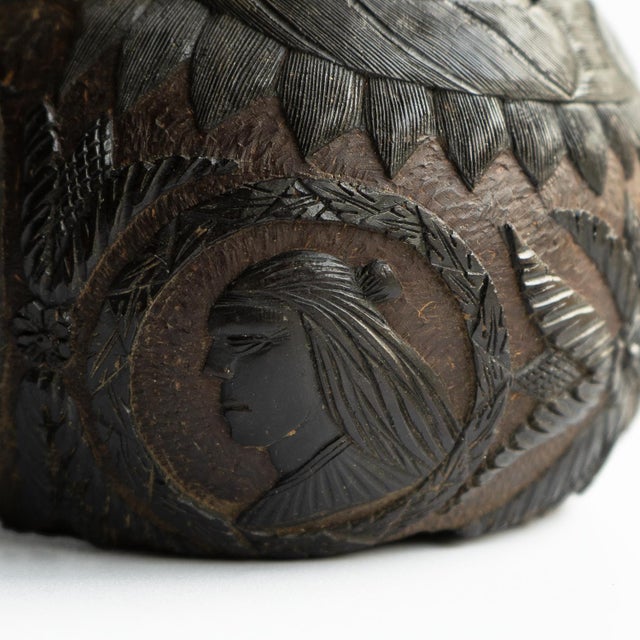 ANTIQUE FOLK ART CARVING An intricately carved coconut with a face on one side which makes use the naturally occurring...