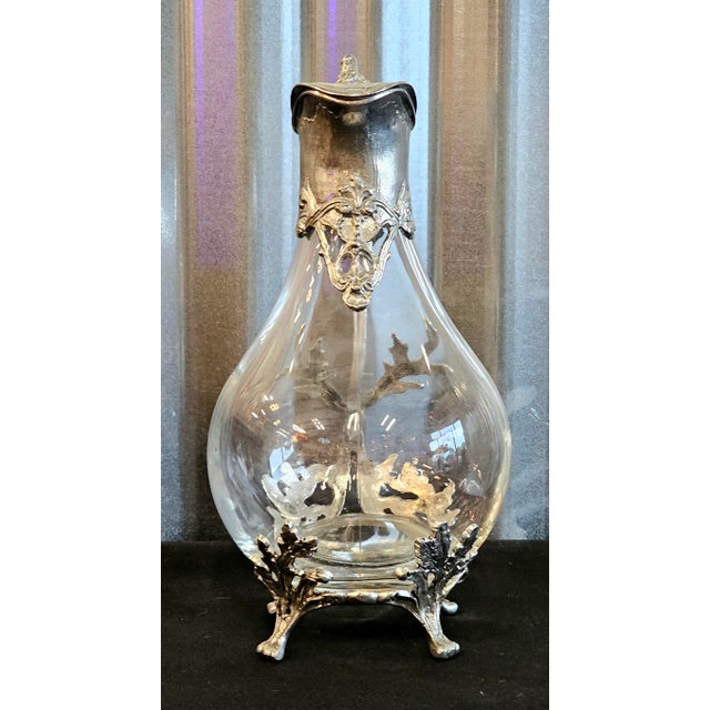 A striking vintage glass claret jug or pitcher featuring an ornate 95% tin pewter (Étain) mount in an elegant French-...
