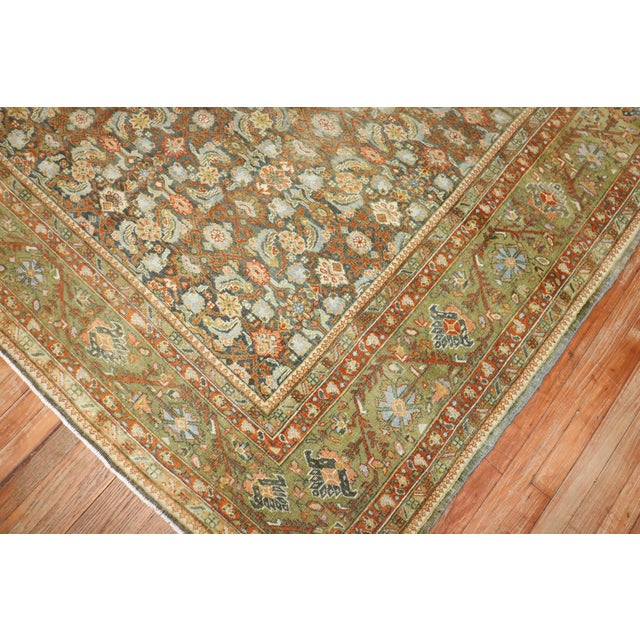 An earth color 1930s Persian herati design Rug highlighted by coral and chartreuse accent colors