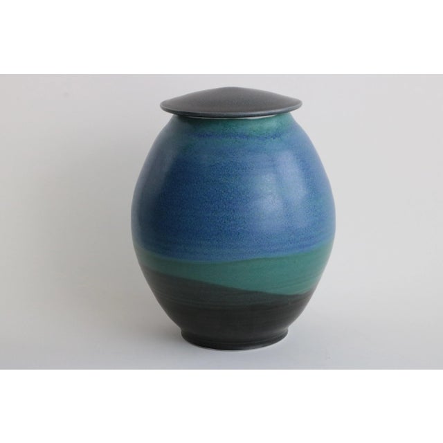 This ovoid lidded jar was handmade by Madison, Wisconsin studio potter Joanne Kirkland and is dated 2001. Executed in...