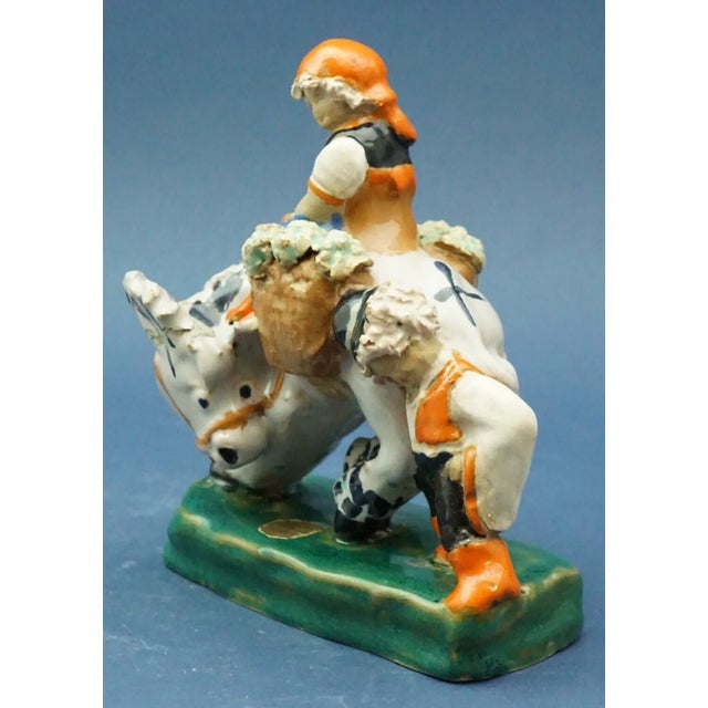 A delightful ceramic sculpture, entirely hand-crafted, glazed, and decorated, depicting a pair of children in traditional...