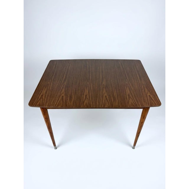 Vintage Mid-Century Modern wood and Formica dining table featuring tapered legs with metal tips. H: 30.5 inches W: 47...