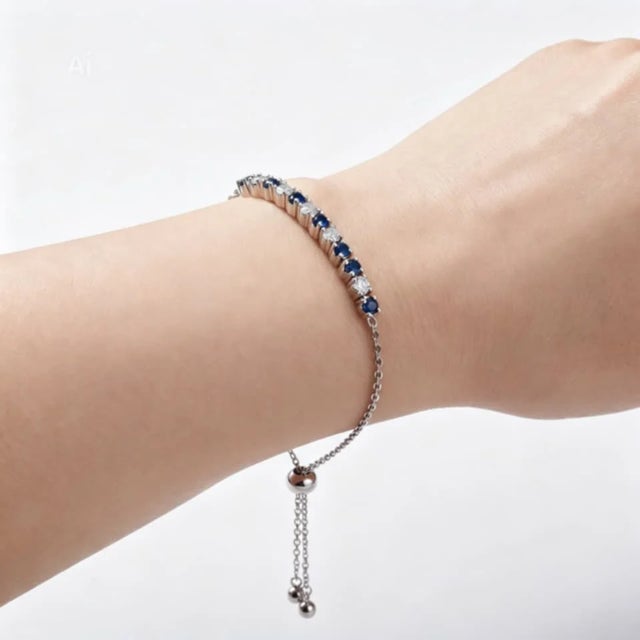 Elegant 14K white gold expandable bracelet featuring brilliant round diamonds and blue sapphires totaling 1 carat. Estate...