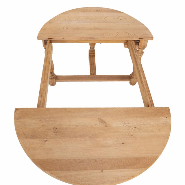 A versatile pair of French solid oak demi-lune console tables featuring turned legs and stretcher bases. Designed to...