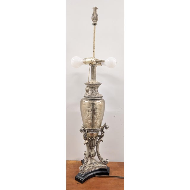 Illuminate your space with sophisticated vintage glamor with this striking urn-shaped table lamp, crafted from silver-...
