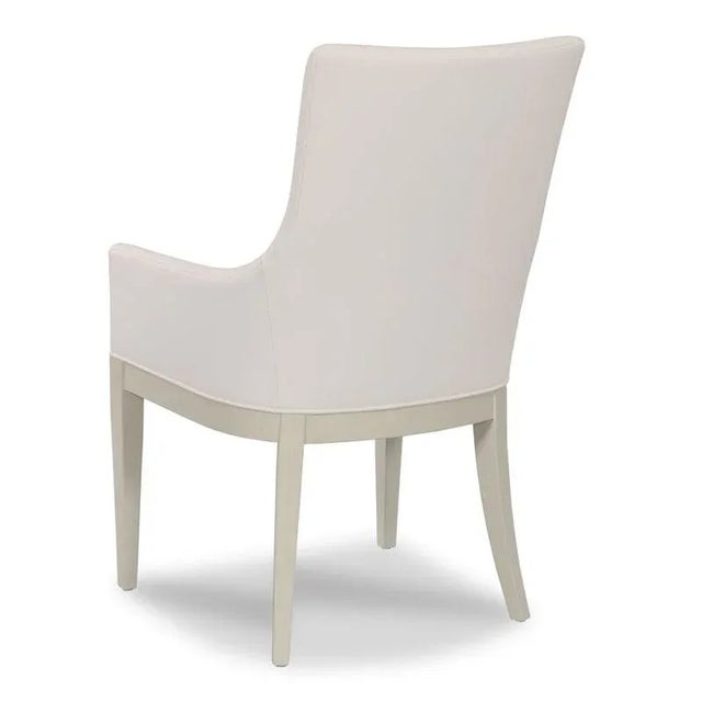A curved upholstered back rests above an upholstered seat raised by tapering legs.