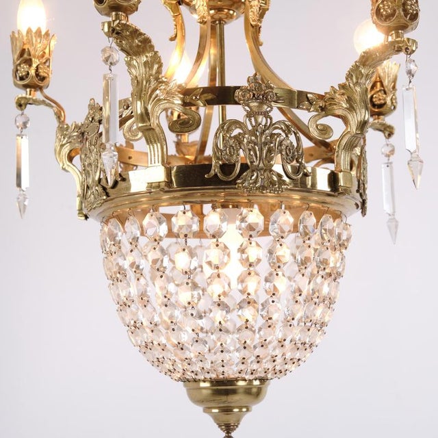 Antique French crystal chandelier from around 1890, designed with prisms and decorative details in gilt bronze. The...