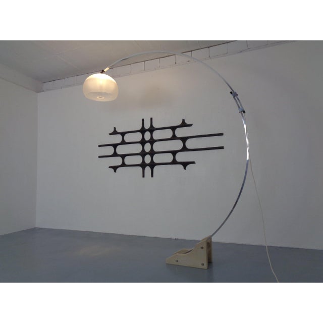 Large Italian arc lamp by Guzzini, made of chrome-plated metal with a travertine base, dating from the 1970s. The lamp's...