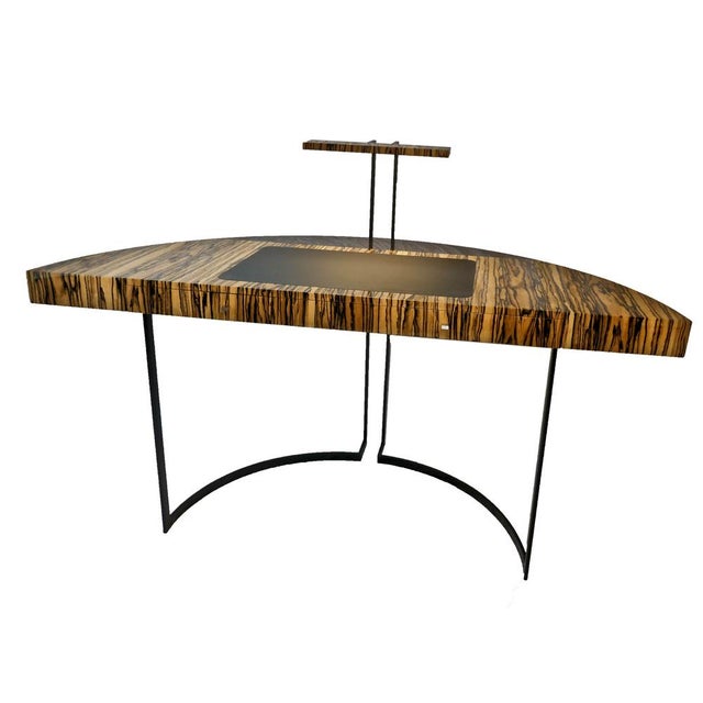 Semi-circular desk with black lacquered metal legs, a white ebony veneer top, and a black leather writing surface. The...