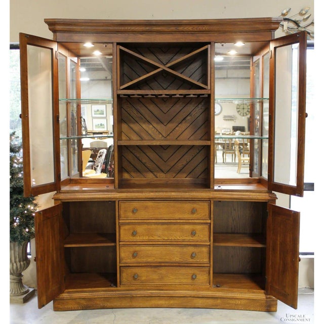 Crafted in a traditional style, this oak case piece features a gently curved front, crown molding, and paneled cabinet...