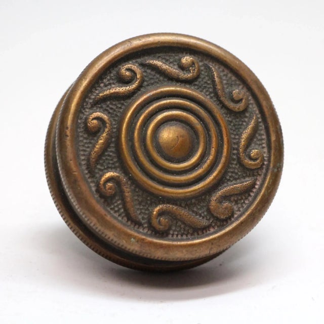 This concentric passage bronze door knob was in the 1900 catalog. The manufacturer is unknown. It is part of the M-11900...