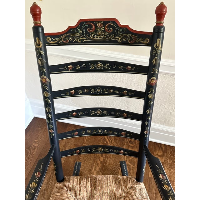 Beautifully detailed stenciled rocking chair with ladder back and rush seat. Black with mostly red, sage green, cream...