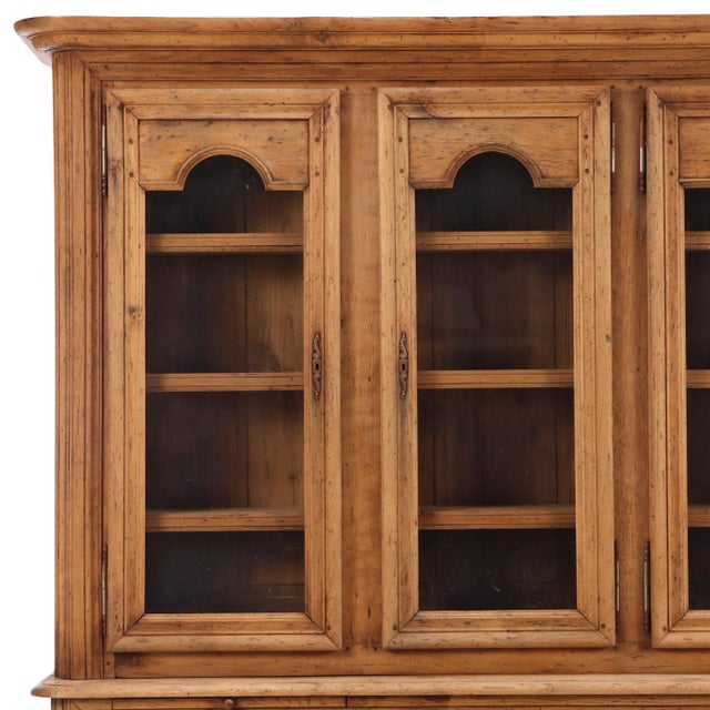 A handsome Belgian two-piece breakfront cabinet crafted in solid oak, dating to circa 1940. This substantial case piece...