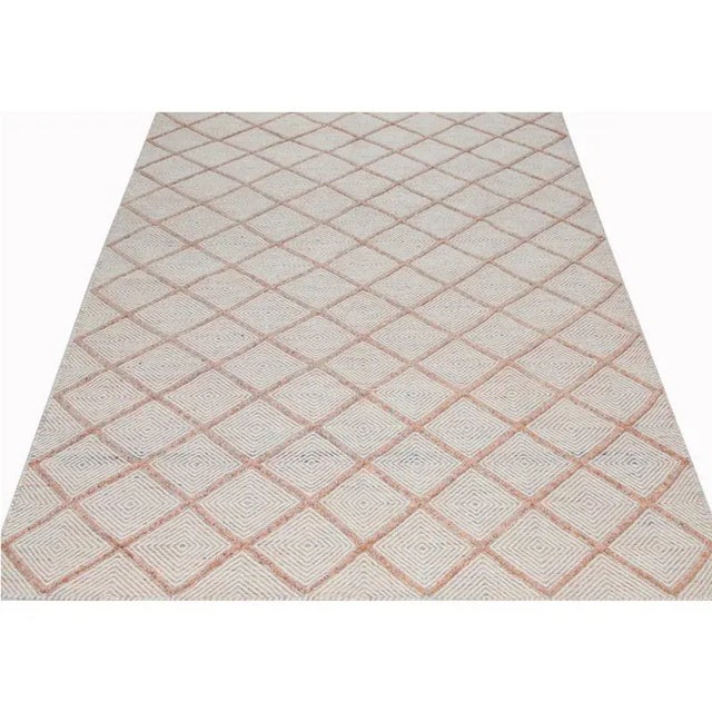 Transitional Handwoven Scandinavian style Area Rug featuring an all-over design in the salmon and ivory-colored field....