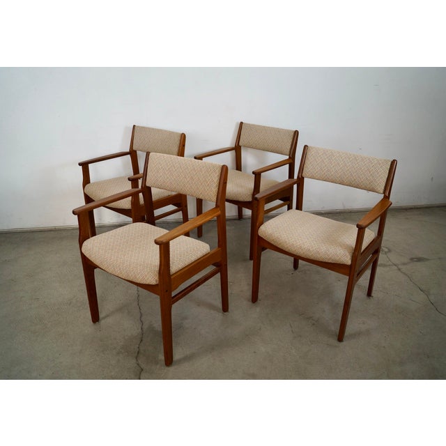 Set of four Mid century Danish Modern dining arm chairs for sale. These are made of solid teak, and were previously...