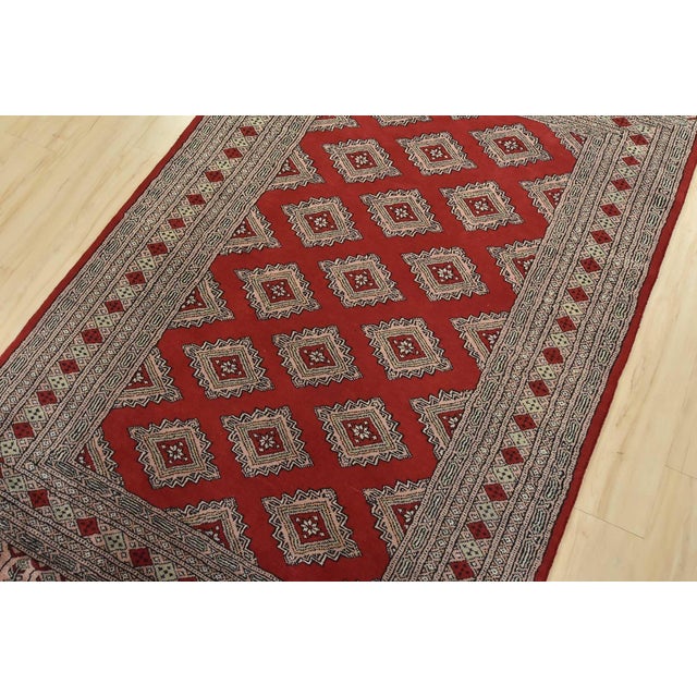 A tribal Bokhara Jaldar rug hand-knotted with fine wool on a cotton foundation. This rug features rows of repeating...