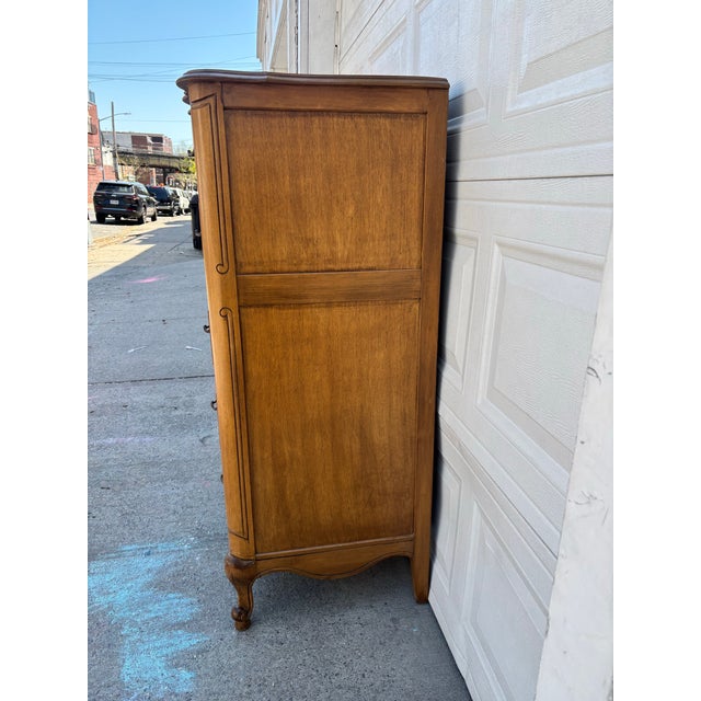 We have a beautiful French Provincial style tall chest for sale. This elegant vintage dresser features a classic Louis XV...