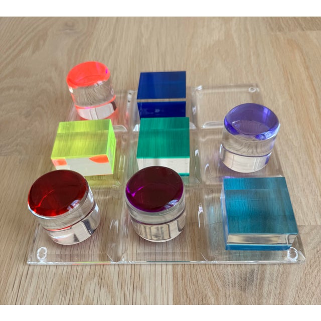 A playful 1980s tic-tac-toe set rendered in substantial clear and brilliantly colored Lucite. The transparent game board...