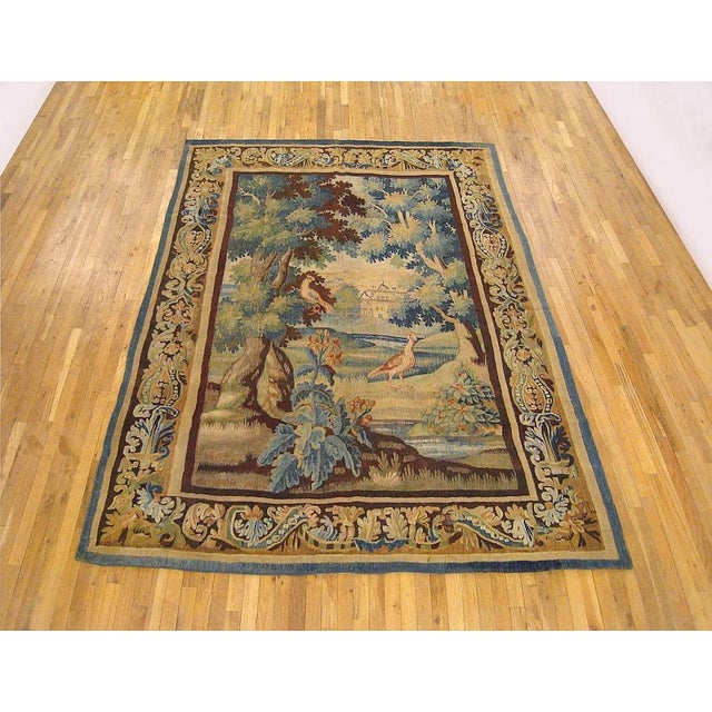 A Flemish verdure landscape tapestry from the 18th century, featuring two cranes in a lush verdant landscape, with various...