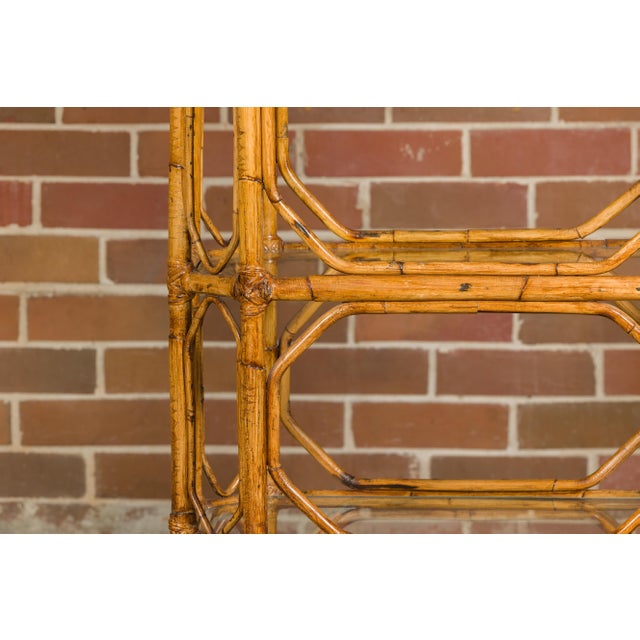 A Midcentury bamboo and glass étagère with five shelves and geometric accents. Step into the world of Midcentury elegance...
