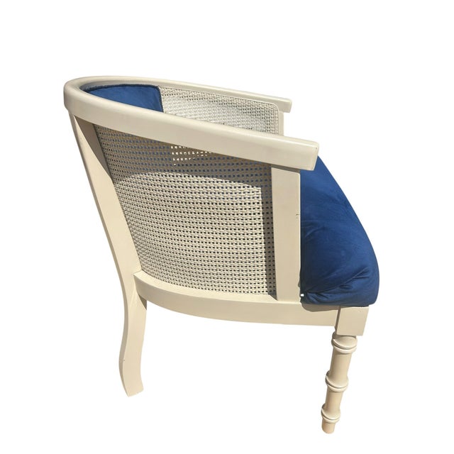 Elegant vintage Hollywood Regency accent chair featuring a sculptural cane back frame upholstered in rich cobalt blue...