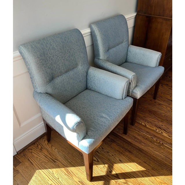 This pair of mahogany frame arm chairs exhibits the flair of mid century modern design as reinterpreted by Thom Filicia...