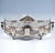 Elegant silver jardinière in an elongated quatrefoil shape, the sides divided by four pilasters featuring floral and...