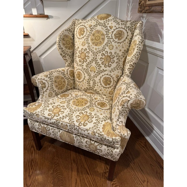 This beautifully crafted wingback chair features a classic Georgian silhouette with high, curved wings, rolled arms, and...