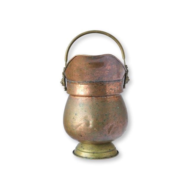 Early 20th century English water pot crafted from warm hammered copper with brass accents and a graceful pouring spout....