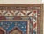 The Rust field scattered with minor stylized flower heads, hooked panels and minute cross-motifs around a column of ivory...