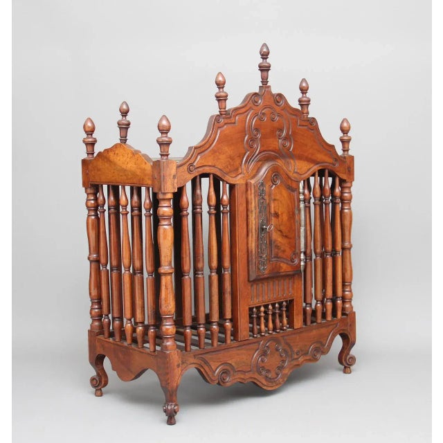 This early 19th-century French fruitwood food cupboard features a carved and shaped top decorated with turned finials. The...
