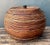 With its rounded form and warm amber patina, this vintage pencil reed lidded basket brings natural texture and relaxed...