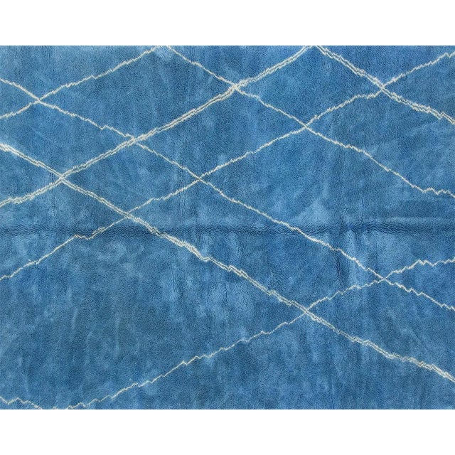 Ocean depths meet timeless pattern. This hand-knotted Moroccan wool rug immerses a space in vibrant cerulean blue,...