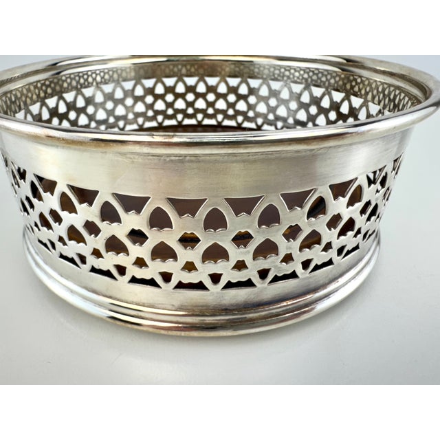 A beautiful vintage wine and decanter coaster featuring an intricately pierced silverplate gallery surrounding a richly...