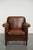 This vintage Art Deco armchair is made of sheepskin and has a rugged patina. It has a removable seat cushion with a few...