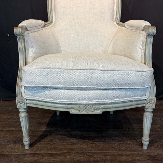 Elegant pair of antique French Louis XVI bergère armchairs featuring beautifully carved and painted wood frames with...
