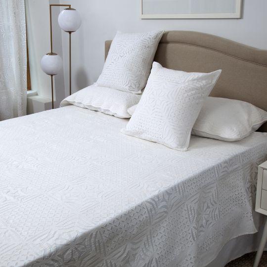 A sophisticated geometric pattern is cut out in white cotton fabric and hand-sewn on sheer cotton organdy to make the...