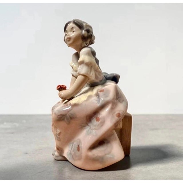 “lolita” porcelain figurine, model no. 5372, designed by salvador debón for lladró, spain. the figure depicts a seated...