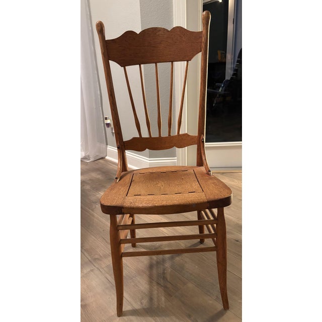 Classic pressed back design with carved details and spindles, typical of American furniture in the late 19th to early 20th...
