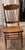 Classic pressed back design with carved details and spindles, typical of American furniture in the late 19th to early 20th...