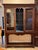 19th century cabinet on stand with a stepped cornice over two glazed doors flanking an open center section with a shaped...
